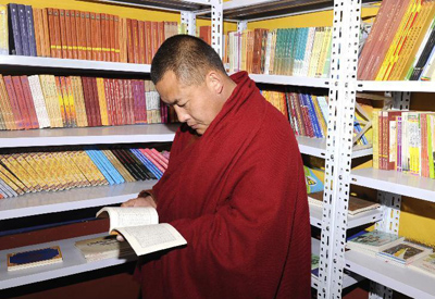 12月19日，在西藏墨竹工卡县塔巴寺，一名僧人在书屋内看书。截至目前，西藏自治区已建设480个寺庙书屋，每个寺庙书屋平均配备出版物354种、1052册（盘），内容涉及佛教典籍、西藏历史、文化教育、卫生保健等。 