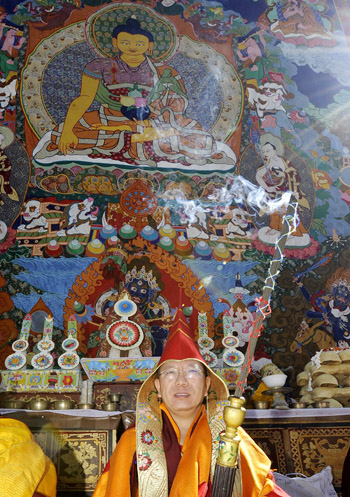 3月8日，贡嘎曲德寺举行展佛，一名僧人手持佛香端坐在前面。