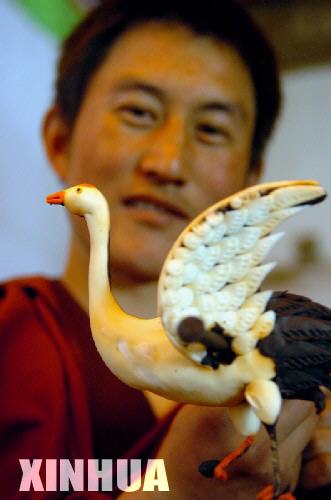 2月11日，塔尔寺艺僧更嘎在展示自己用酥油制作的天鹅。