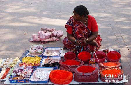 印度那烂陀的菩提加耶，一位买小货的妇女，她的摊子前摆了不少印度传统的染料，颜色相当艳丽。_印度采访图记：朝圣那烂陀_乐途旅游网