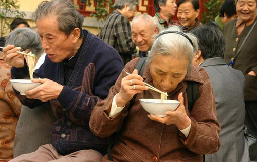 10月19日，几位老人在毗卢寺品尝长寿面。
