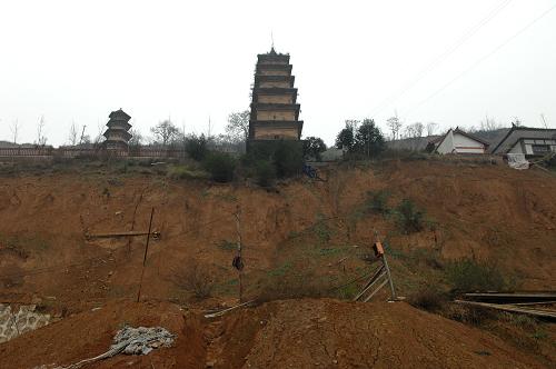 陕西长安华严寺千年古塔面临滑坡威胁 陕西长安华严寺一侧的土坡在滑坡后与地面的角度已经接近九十度(11月21日摄)。 位于陕西西安市长安区少陵原畔的佛教华严宗祖庭——华严寺内仅存的两座古塔面临着山体滑坡造成的巨大威胁。 华严寺内现存的两座古塔于2006年被纳入第六批全国重点文物保护单位。在2011年5月、6月和9月的数次集中降雨中,华严寺周边多处发生山体滑坡,其中建于唐代的杜顺塔的塔基已在滑坡中部分裸露,距离古塔一米左右的地面上裂开了长达数米的裂缝,妙觉塔旁的斋房的地基也遭到极大破坏,寺院内的其他房屋也在滑坡中遭到不同程度的损坏。 由于近期西安仍不时出现降雨天气,已经遭到较大破坏的华严寺古塔目前面临着极大的滑坡威胁。 新华社记者 李一博 摄