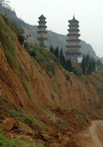 陕西长安华严寺周边的山体发生多处滑坡(11月21日摄)。 位于陕西西安市长安区少陵原畔的佛教华严宗祖庭——华严寺内仅存的两座古塔面临着山体滑坡造成的巨大威胁。 华严寺内现存的两座古塔于2006年被纳入第六批全国重点文物保护单位。在2011年5月、6月和9月的数次集中降雨中,华严寺周边多处发生山体滑坡,其中建于唐代的杜顺塔的塔基已在滑坡中部分裸露,距离古塔一米左右的地面上裂开了长达数米的裂缝,妙觉塔旁的斋房的地基也遭到极大破坏,寺院内的其他房屋也在滑坡中遭到不同程度的损坏。 由于近期西安仍不时出现降雨天气,已经遭到较大破坏的华严寺古塔目前面临着极大的滑坡威胁。 新华社记者 李一博 摄