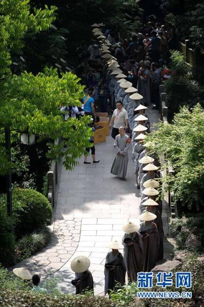 5月10日，参加托钵行脚慈善活动的僧人们行走在通往灵隐寺的天竺小道上。当日是农历四月初八，释迦牟尼诞辰日，杭州佛教界举行盛大的僧人托钵行脚慈善活动。来自杭州各大寺院及佛学院的300余名僧人托钵行脚，从杭州的法喜讲寺行走到杭州灵隐寺，接受沿途信众的慈善捐赠，所得善款将全部捐赠给相关慈善机构。新华社发