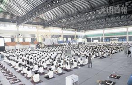 逾千名信众身穿素色活动T恤，齐聚一堂打坐禅修