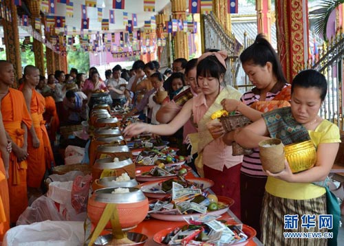 佛教信徒手捧装有贡品的钵供养僧众