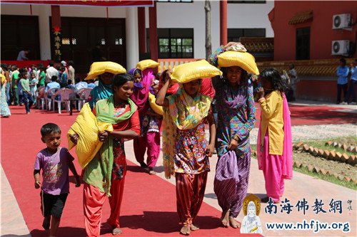 领到爱心大米的尼泊尔居民们脸上充满笑意  摄影：顿俊