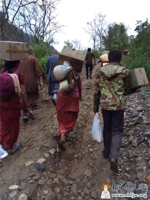 领取到救援物资的灾民，沿着崎岖的山路回家