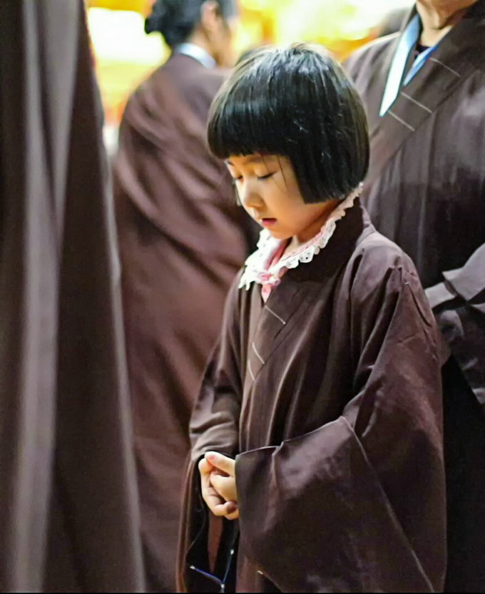 大雄宝殿,萌萌的7岁小朋友正在念佛,认真专注的模样令人心生欢喜"精进