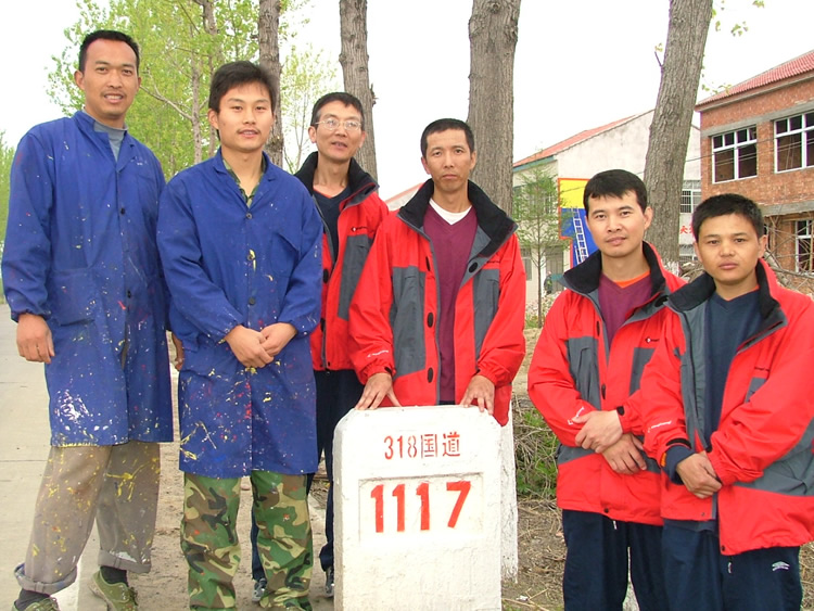 与捐款者合影,他们是在路边做墙体广告的工人